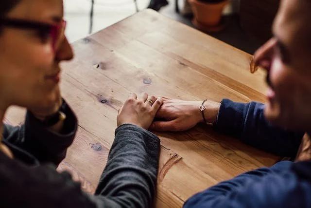 Couple holding hands across a table